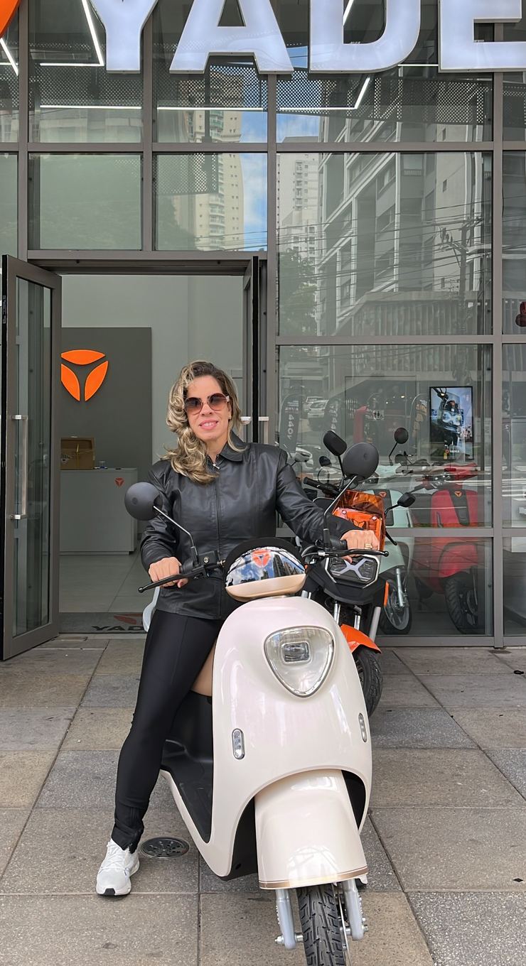 Cliente Yadea com a sua moto elétrica na loja