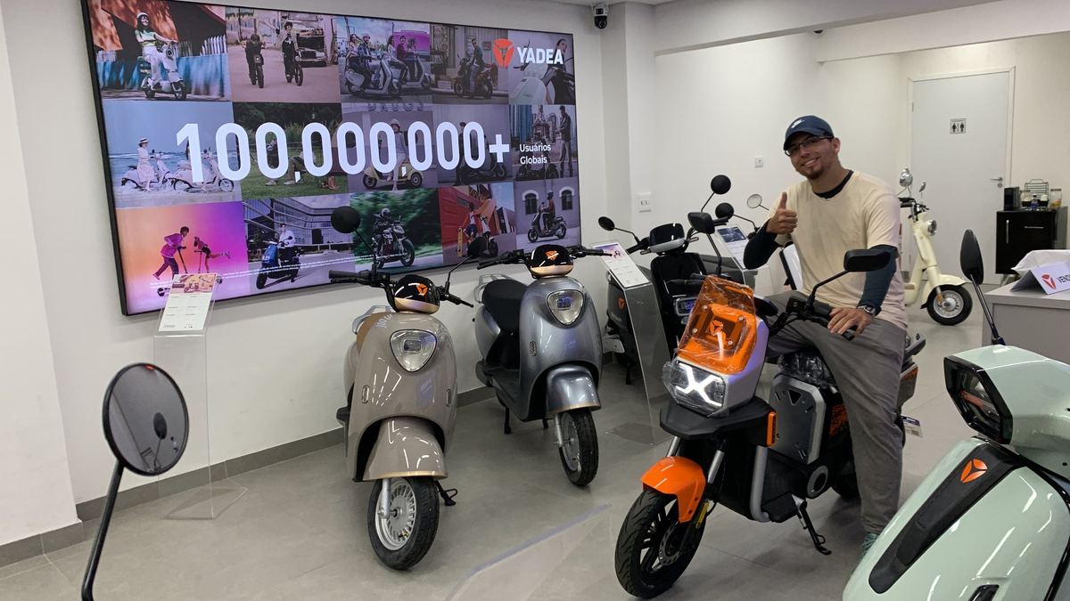 Cliente Yadea com a sua moto elétrica na loja