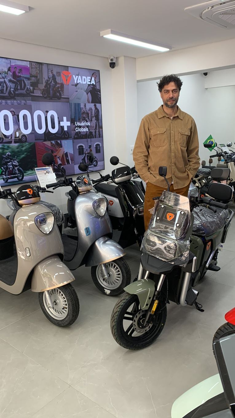 Cliente Yadea com a sua moto elétrica na loja