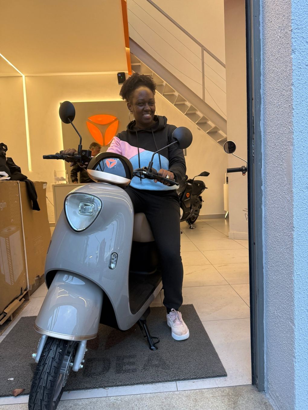 Cliente Yadea com a sua moto elétrica na loja