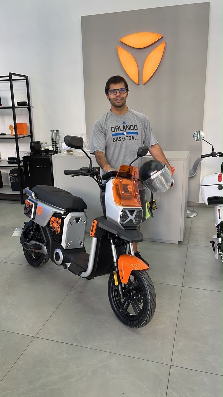 Cliente Yadea com a sua moto elétrica na loja