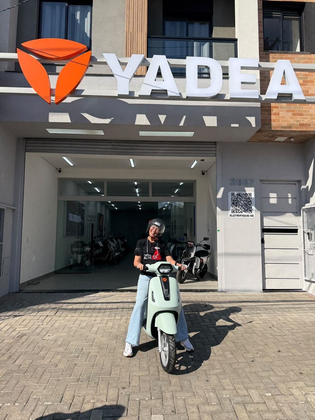Cliente Yadea com a sua moto elétrica na loja